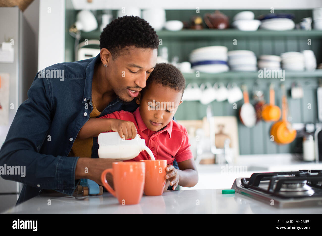 Dad teaching son to make a cup of tea on Mothers Day Stock Photo