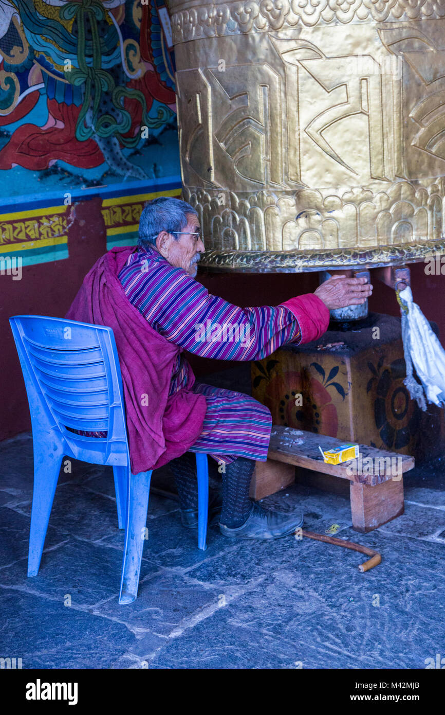 Punakha, Bhutan.  Old Man Turning Prayer Wheel at the Punakha Dzong. Stock Photo