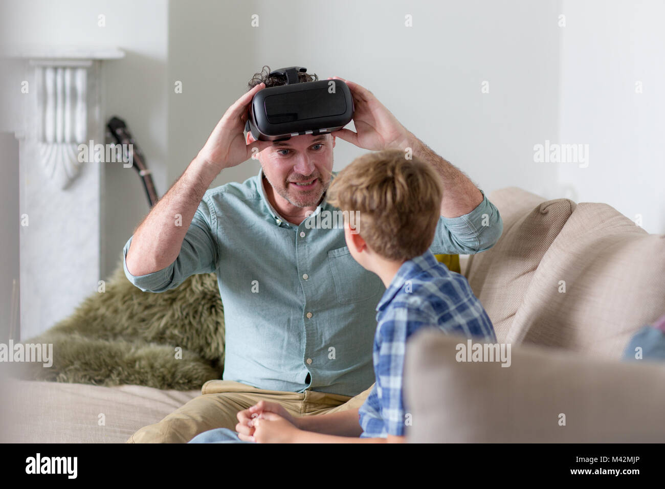 Father and Son using a virtual reality glasses at home Stock Photo