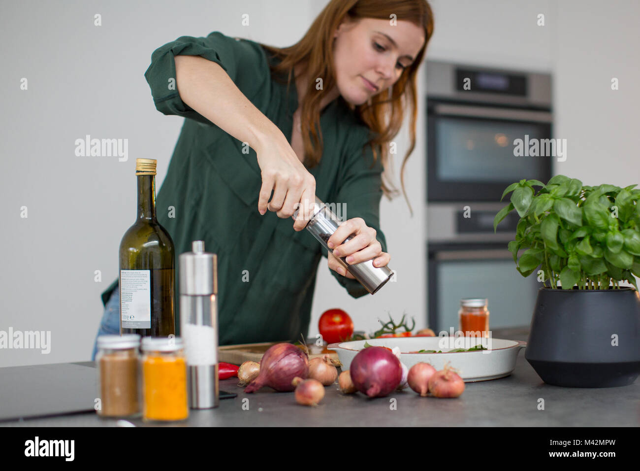 Adult female seasoning a dish Stock Photo
