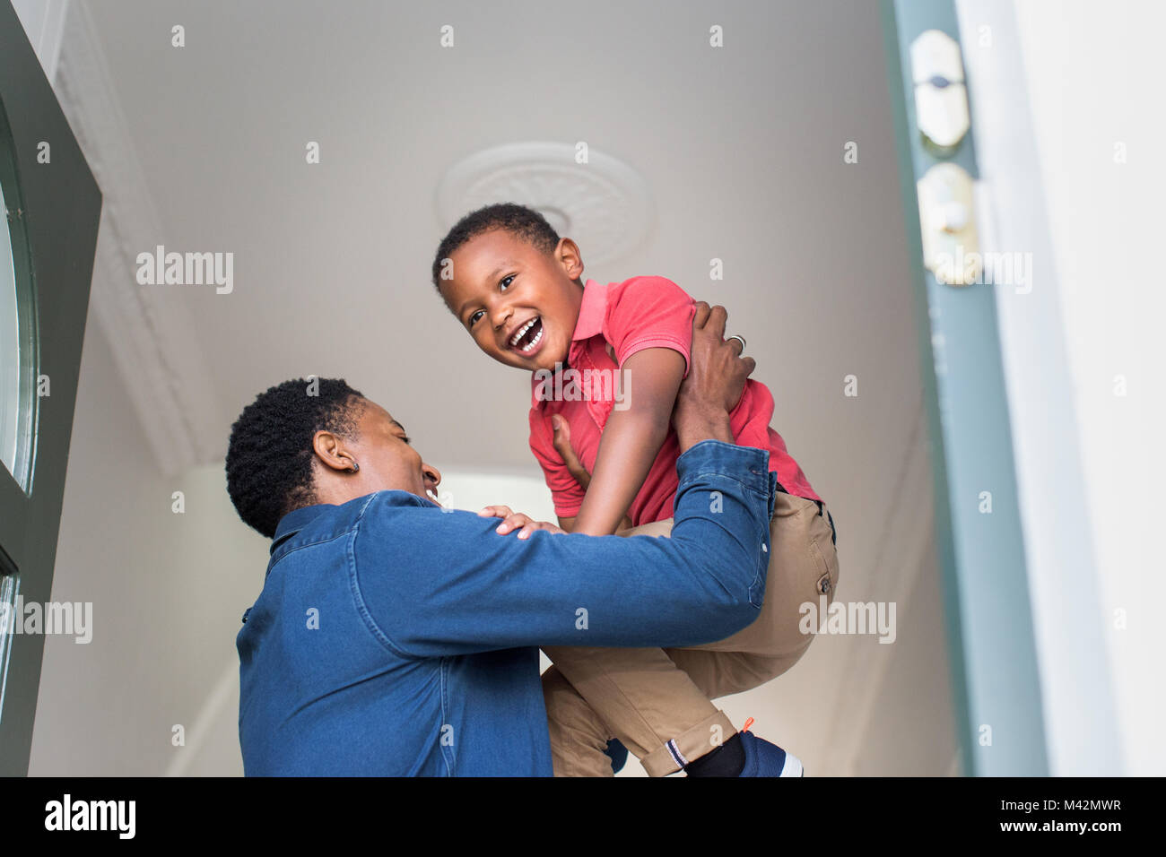 Dad lifting son up as he welcomes him home Stock Photo
