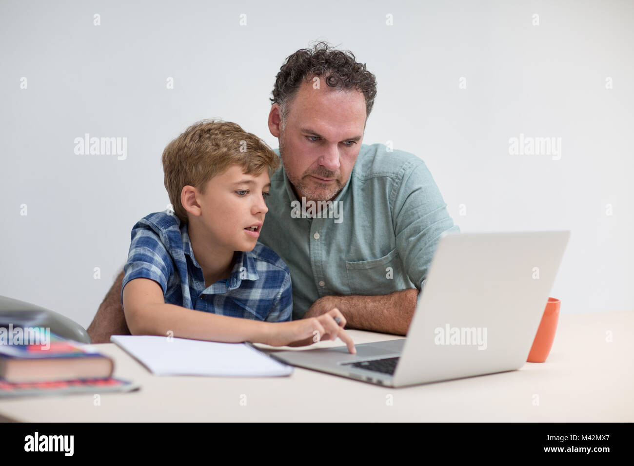 Father helping son with homework Stock Photo