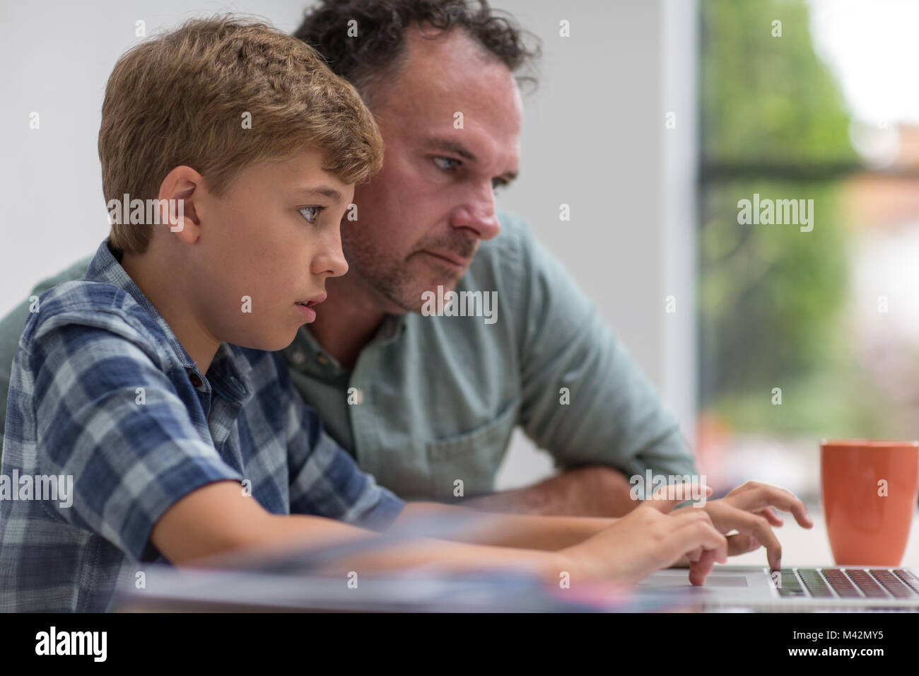 Father helping son with homework Stock Photo