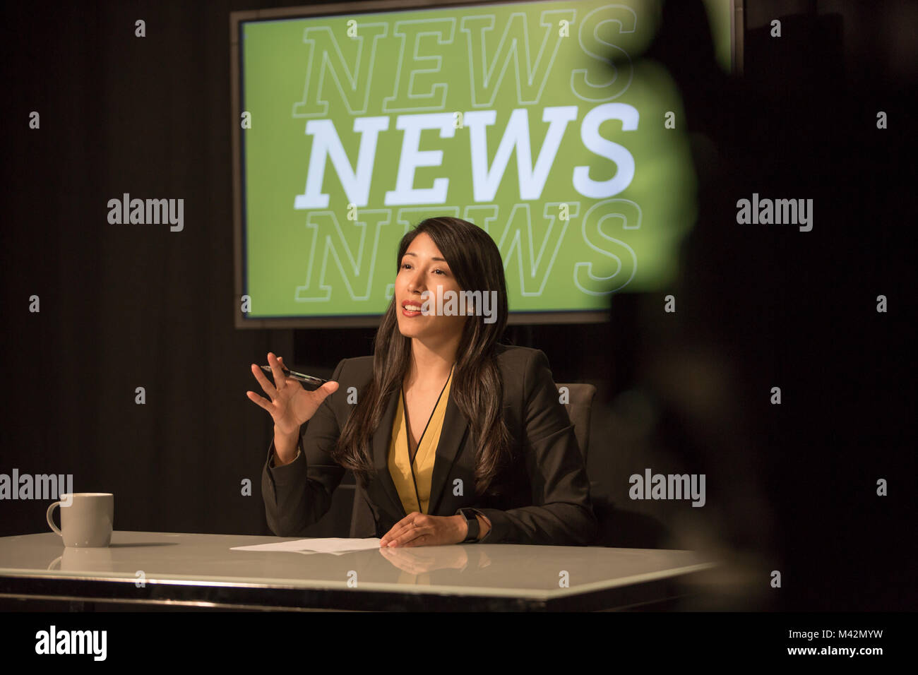 News presenter in a TV broadcasting studio Stock Photo