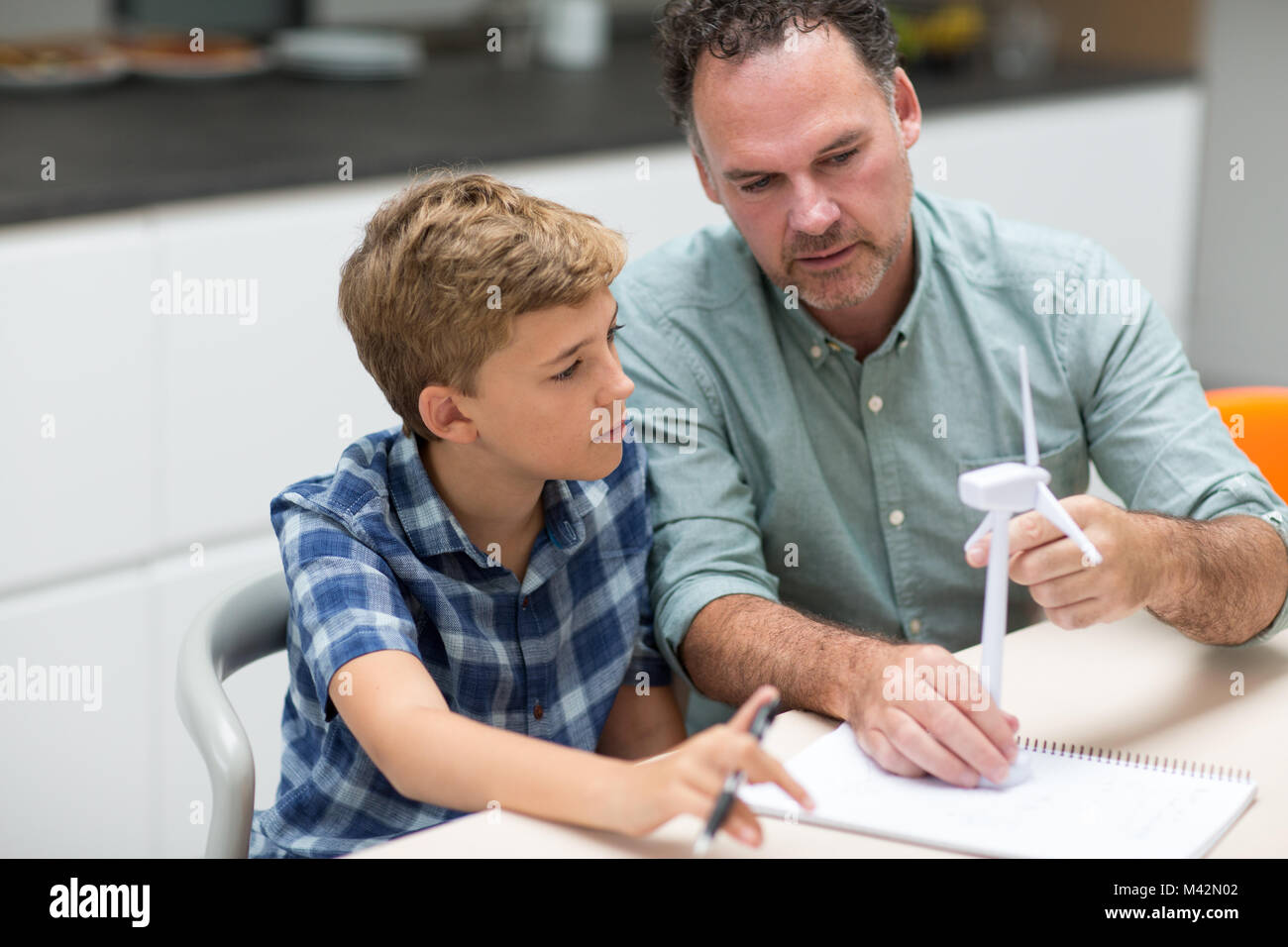 Father helping son with school project Stock Photo