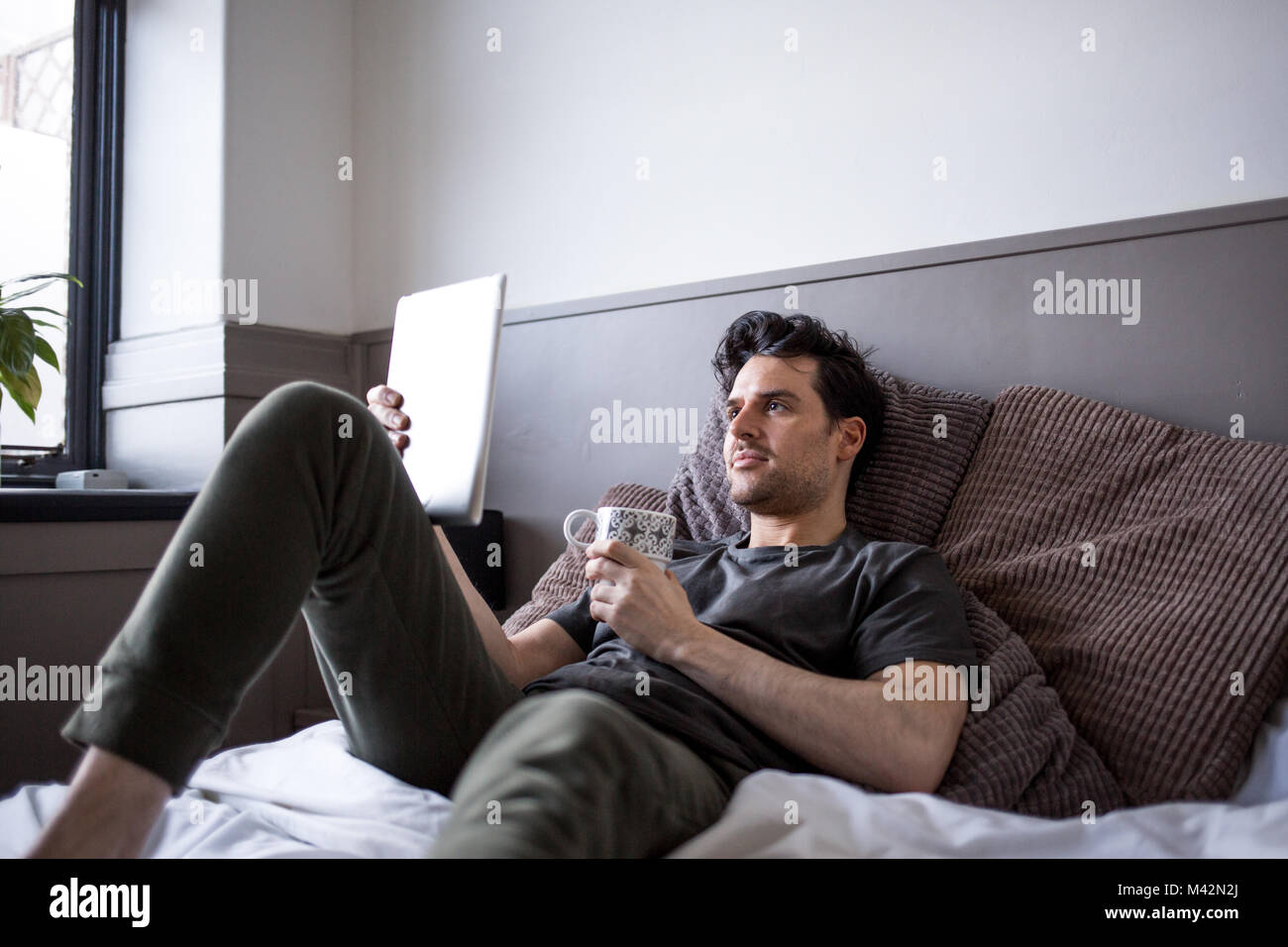 Young male reading on digital tablet Stock Photo
