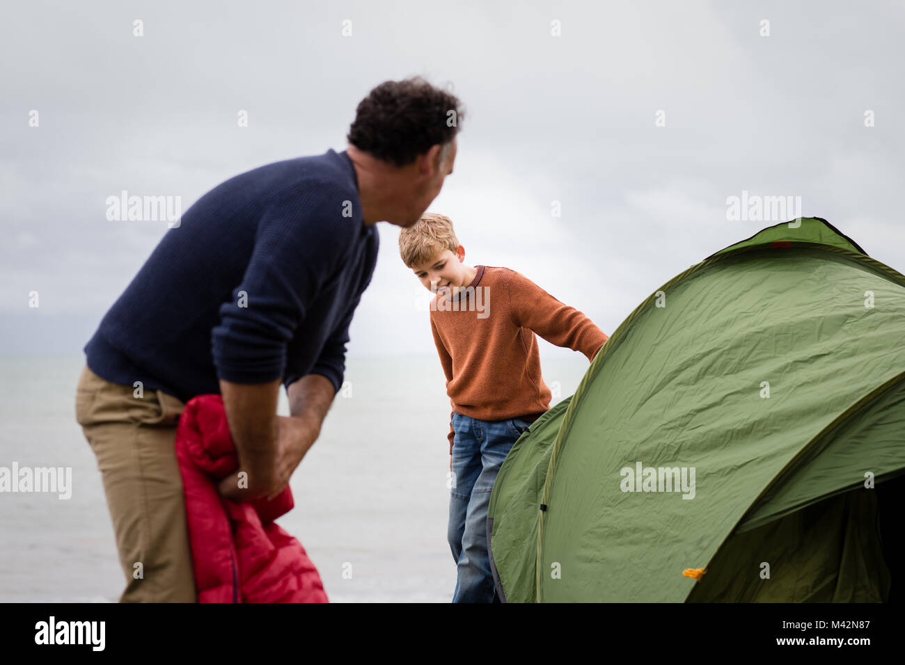 Father and Son putting up a tent together Stock Photo