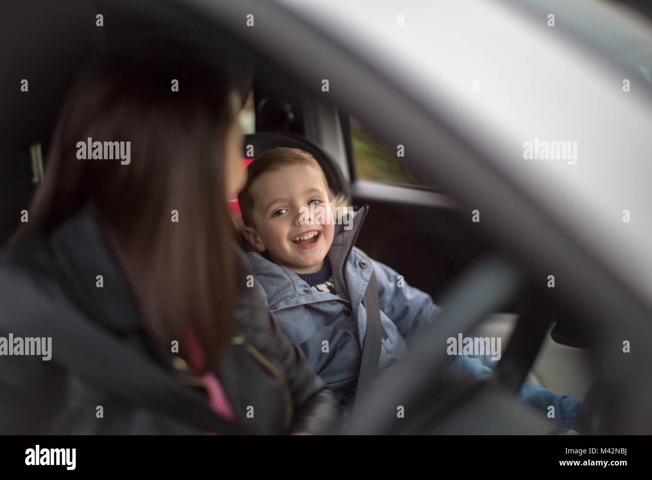 Boy smiling at Mother on car road trip Stock Photo