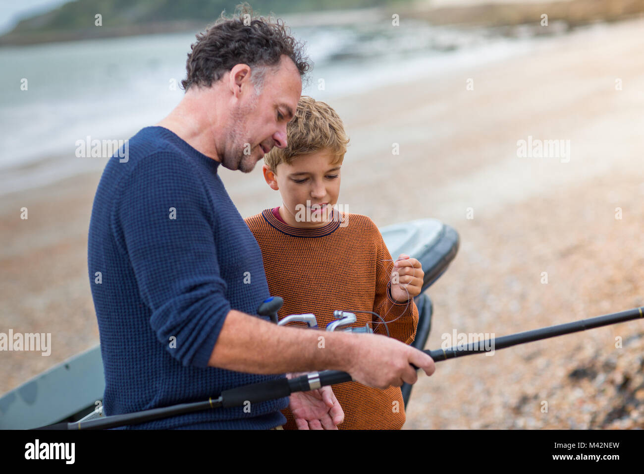 Father and Son setting up a fishing rod together Stock Photo