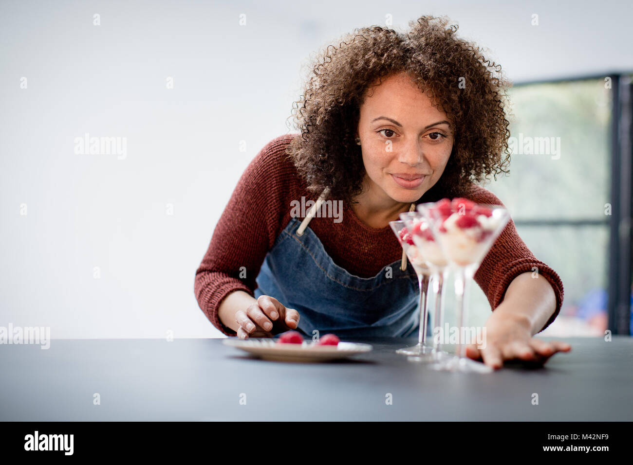 Female cook putting final touches to desert Stock Photo