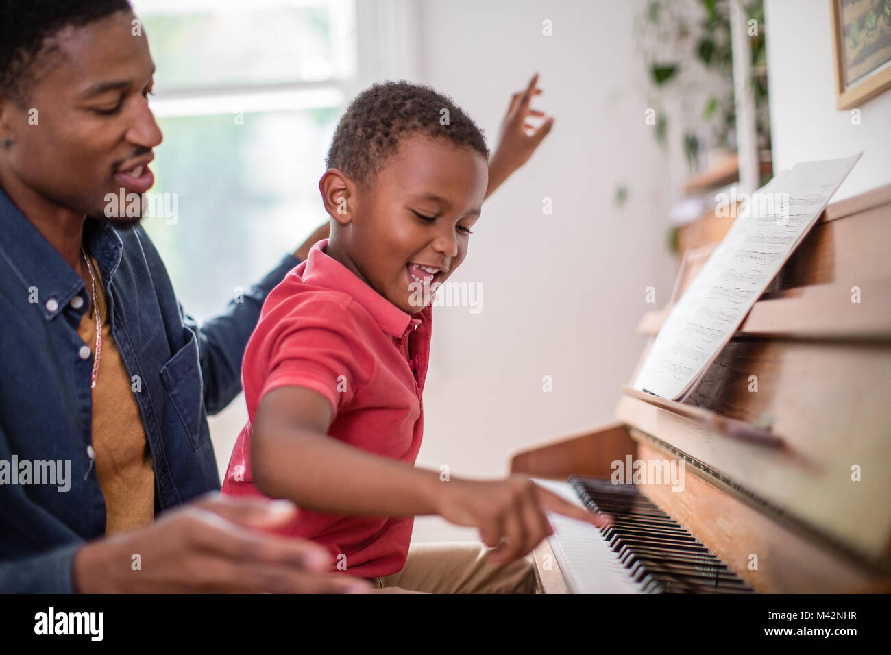 Father teaching Son to play the piano Stock Photo