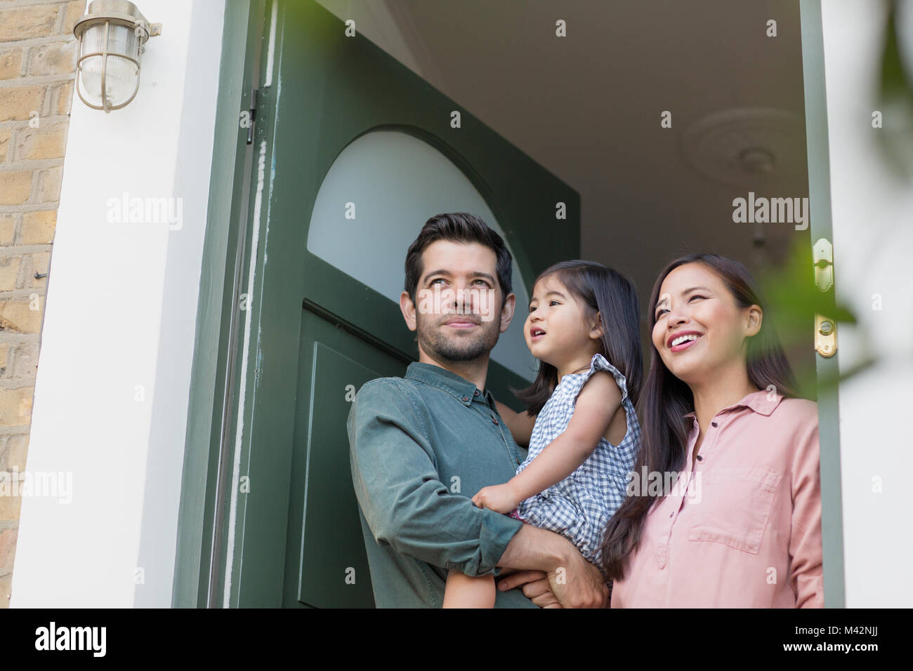 Family standing in doorway of home Stock Photo