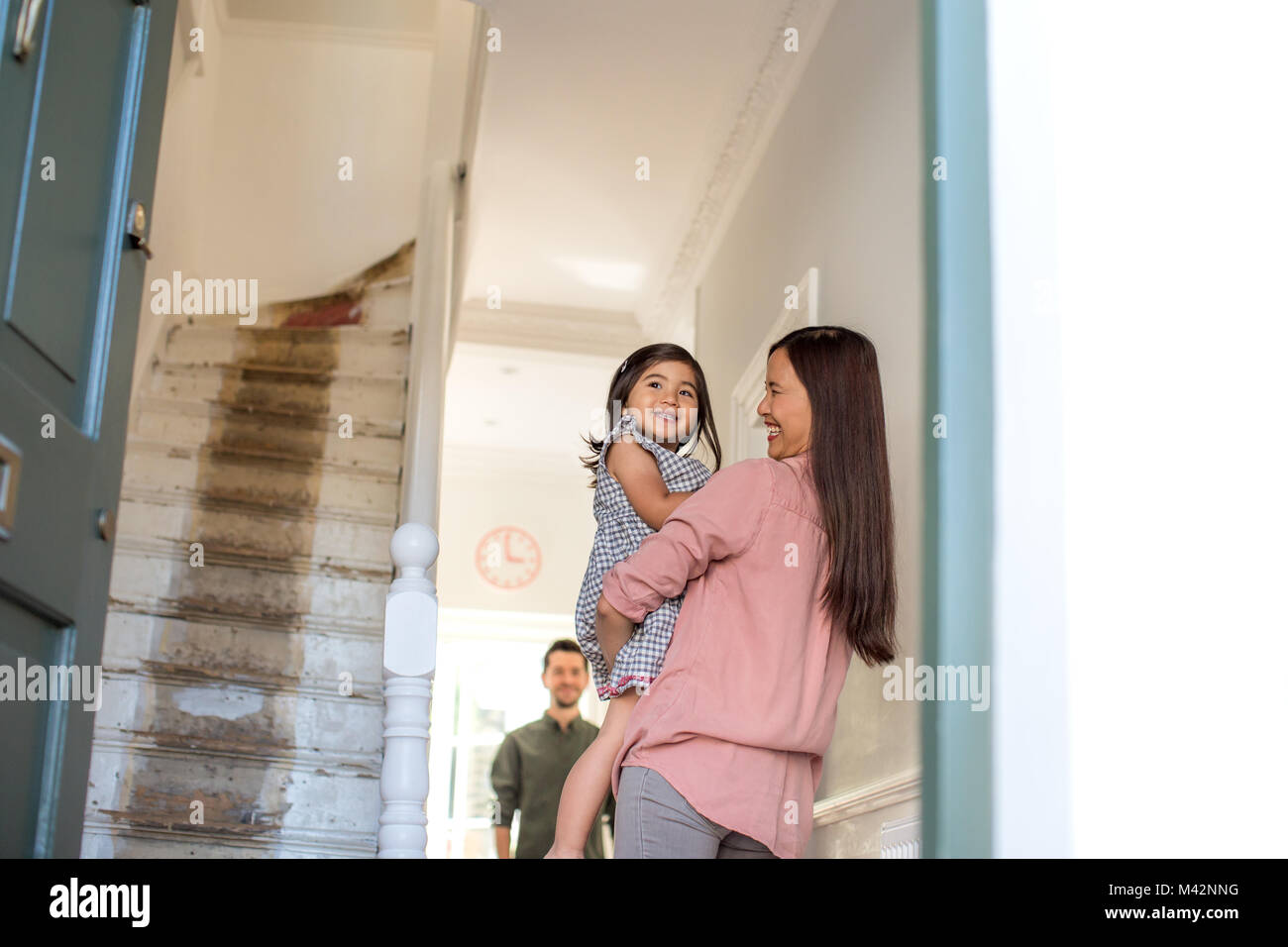Mother carrying daughter home Stock Photo