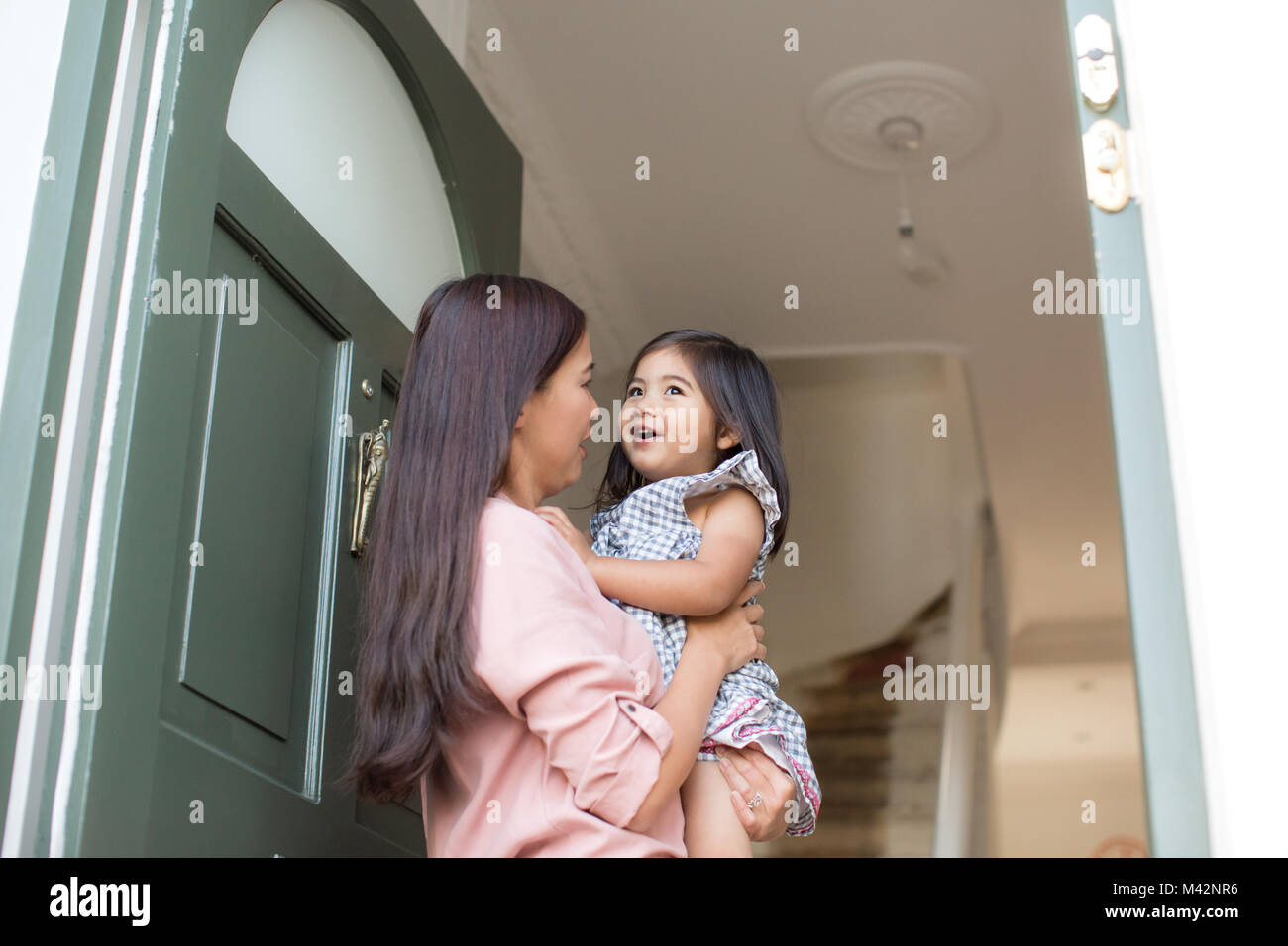 Mother carrying daughter home Stock Photo