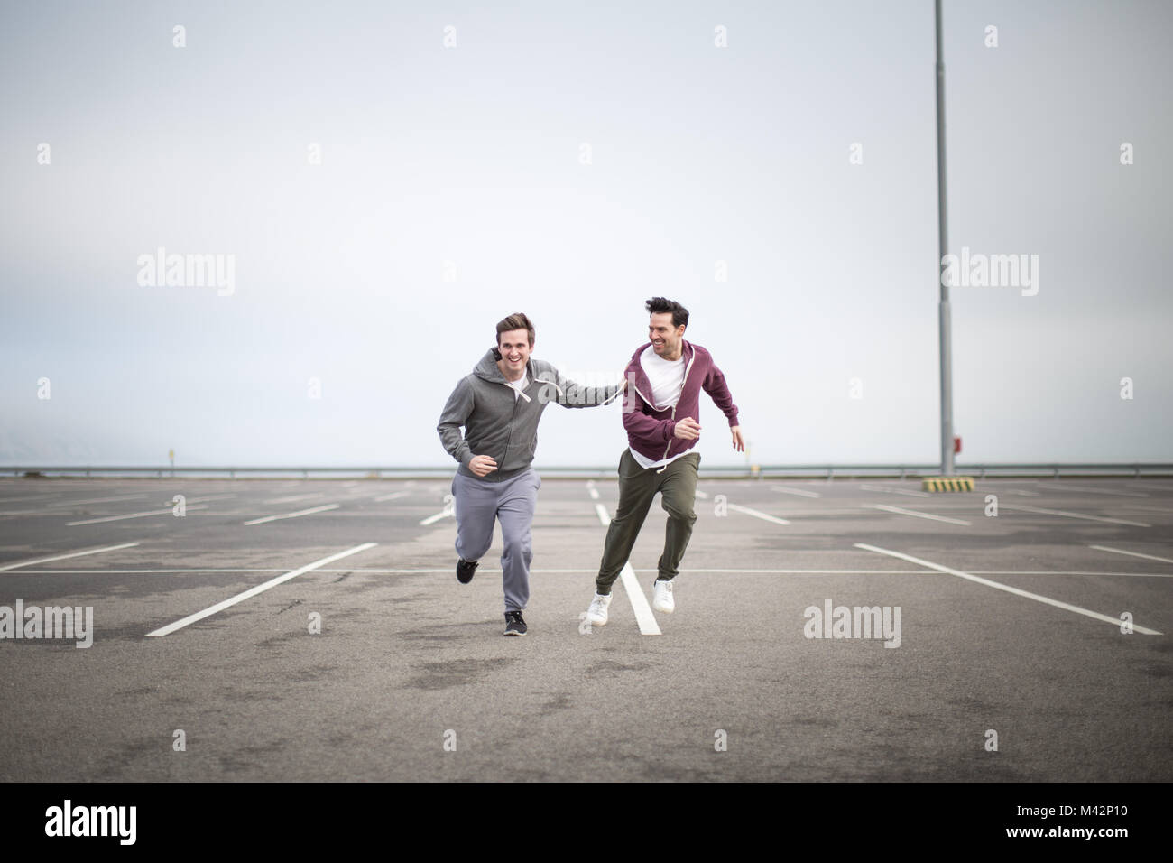 Male friends jogging outdoors Stock Photo