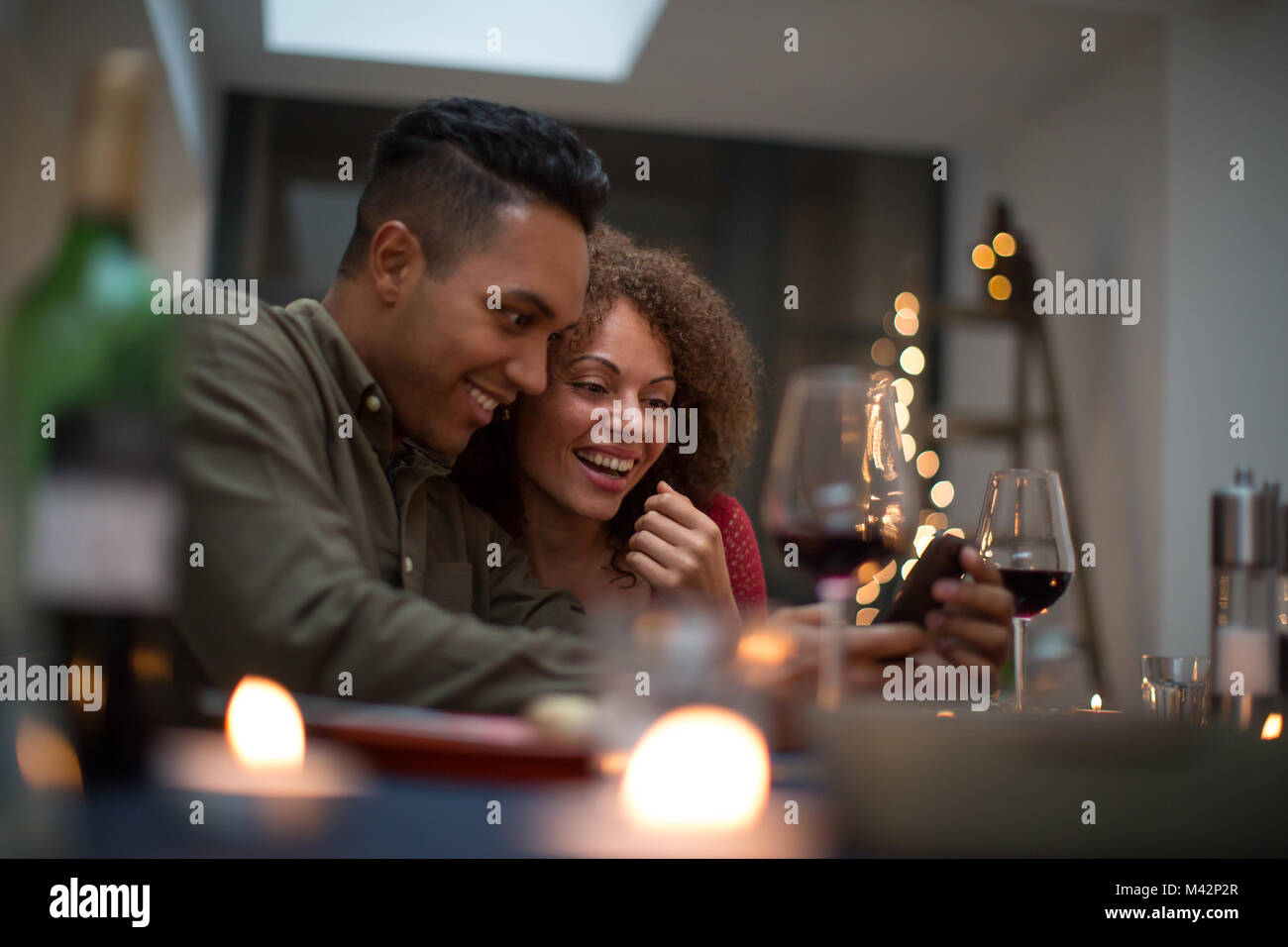 Couple looking at smartphone together at a meal Stock Photo