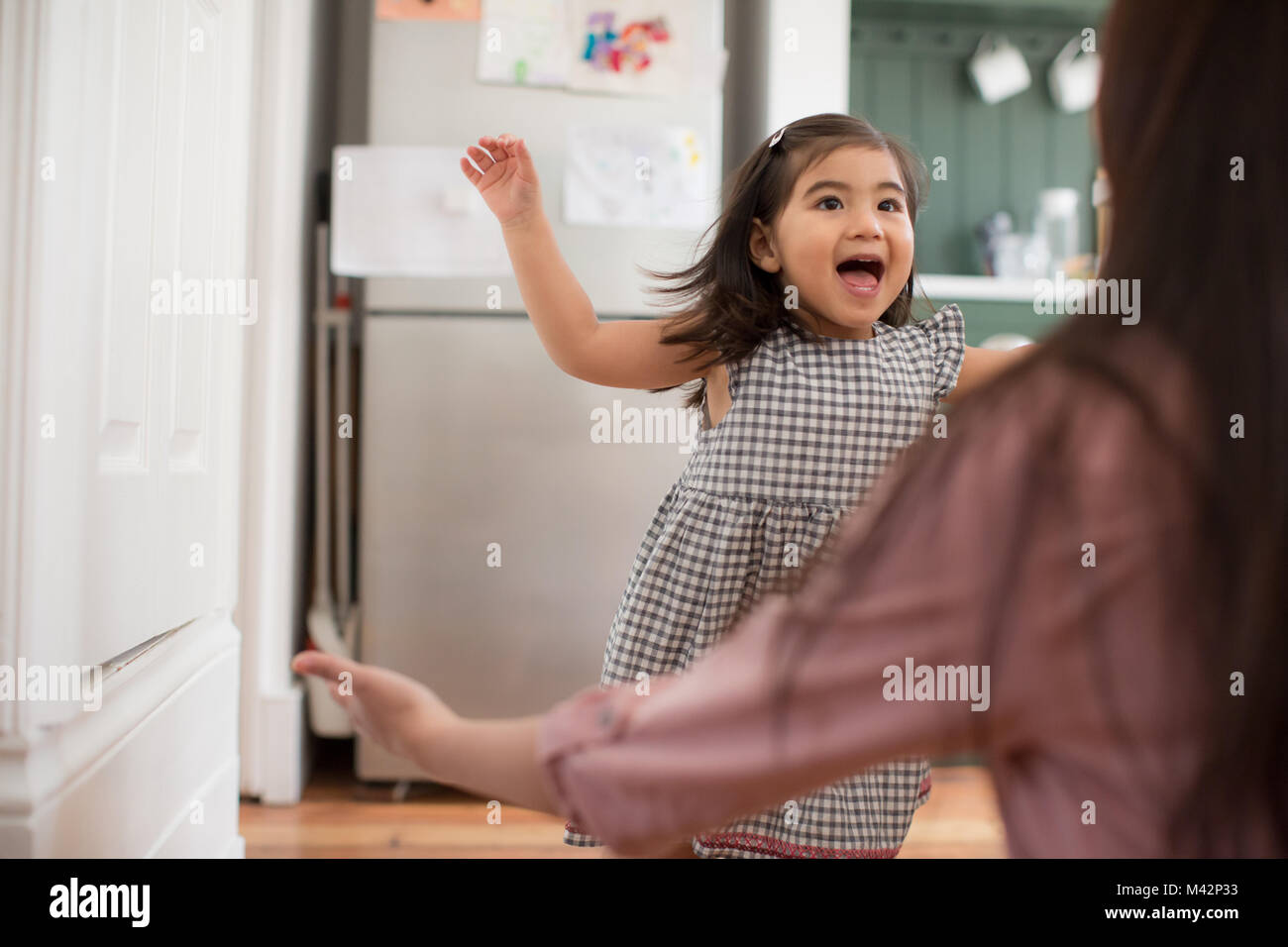 Girl running into mother’s arms Stock Photo