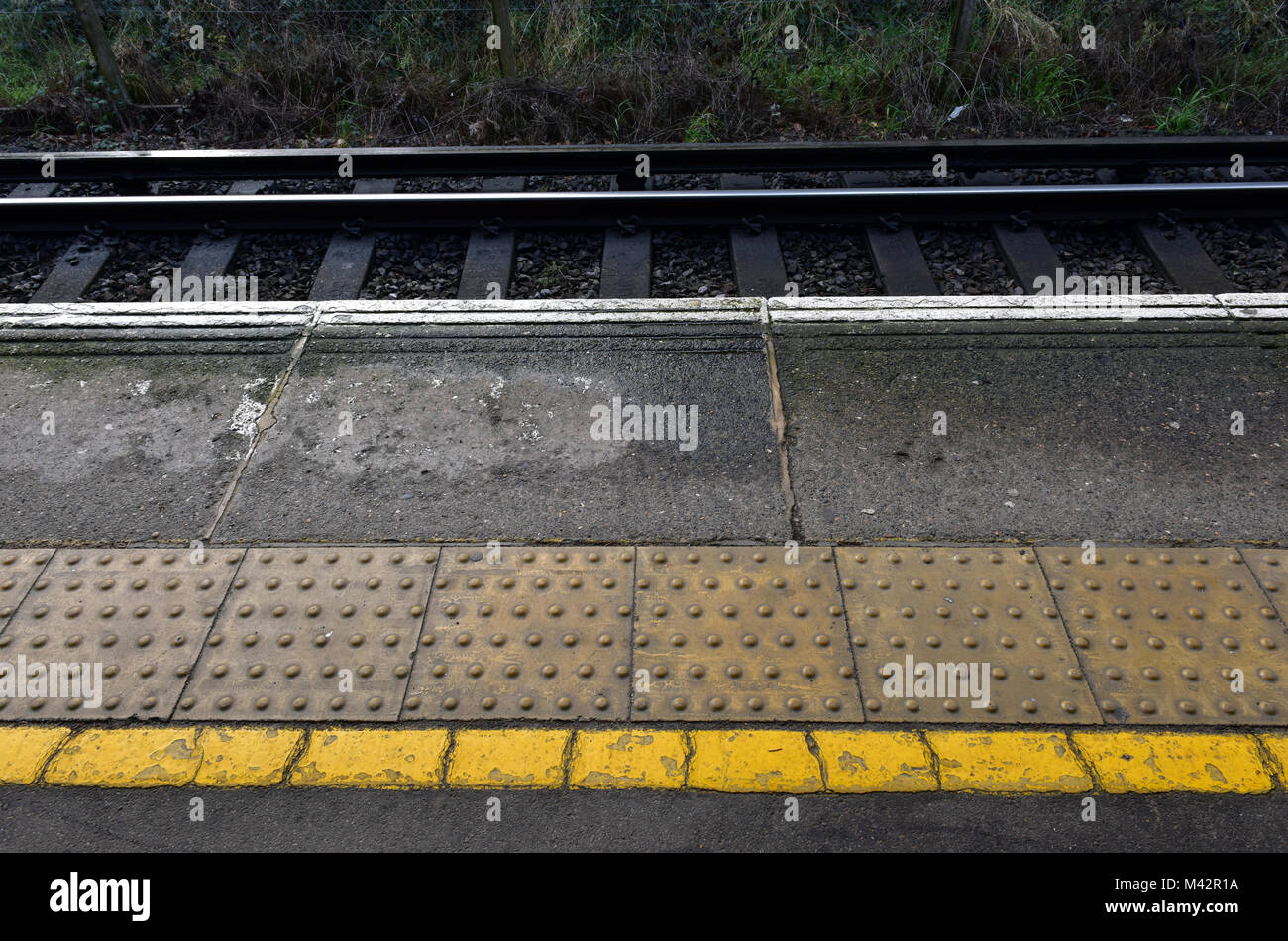 the edge of a platform on a railway or train station with white and