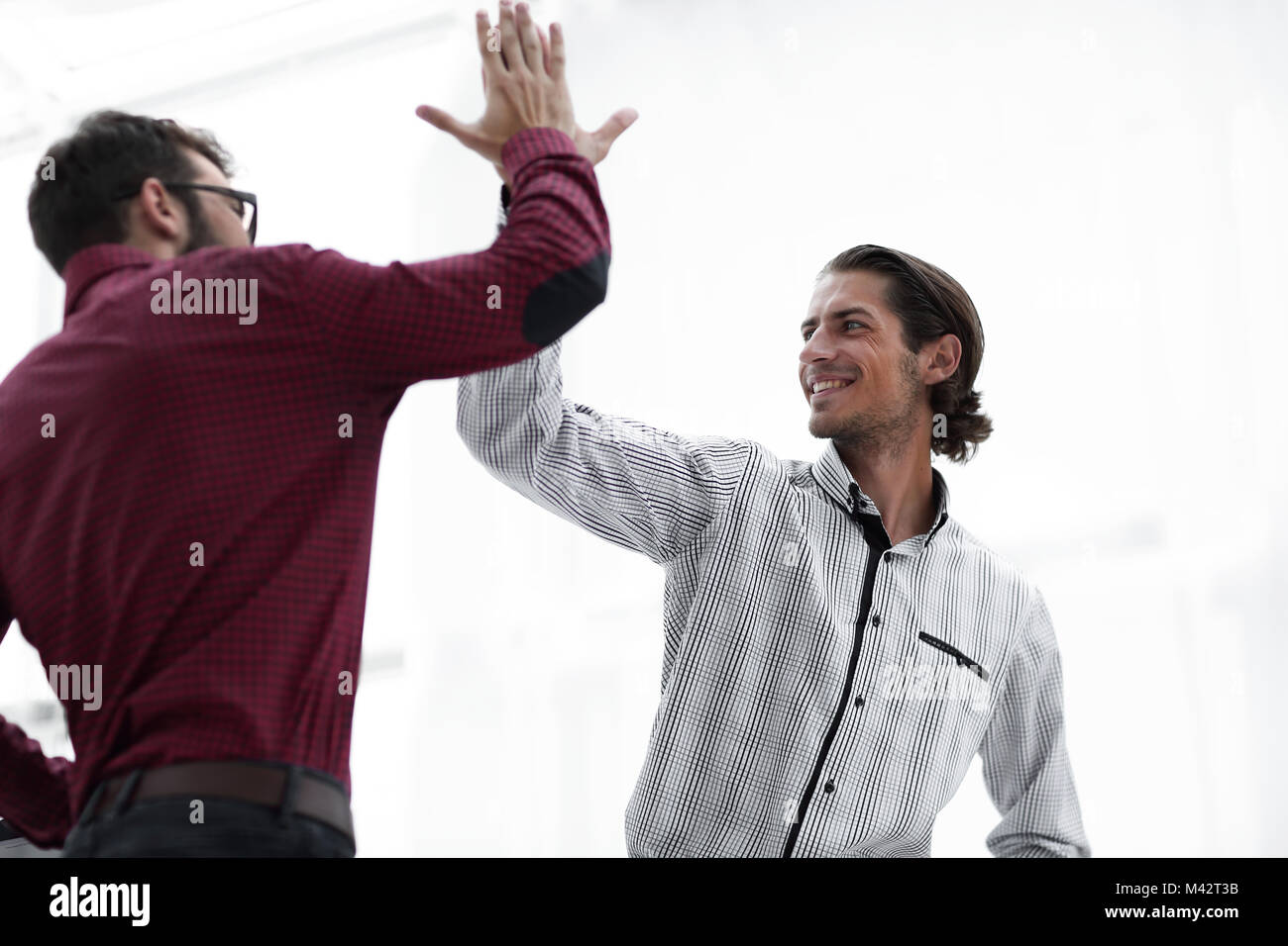 happy colleagues giving each other high five Stock Photo - Alamy