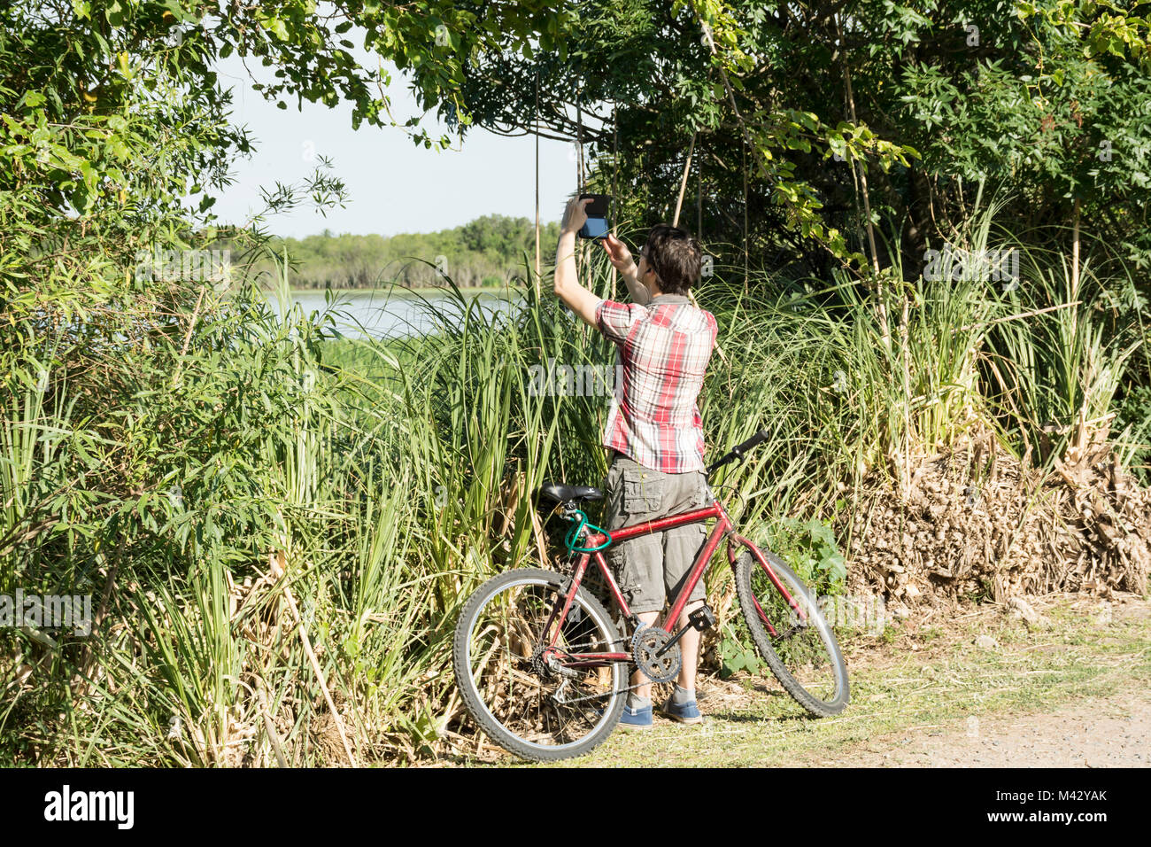 A young man taking a picture in Buenos Aires Costanera Sur Ecological Reserve, Argentina Stock Photo