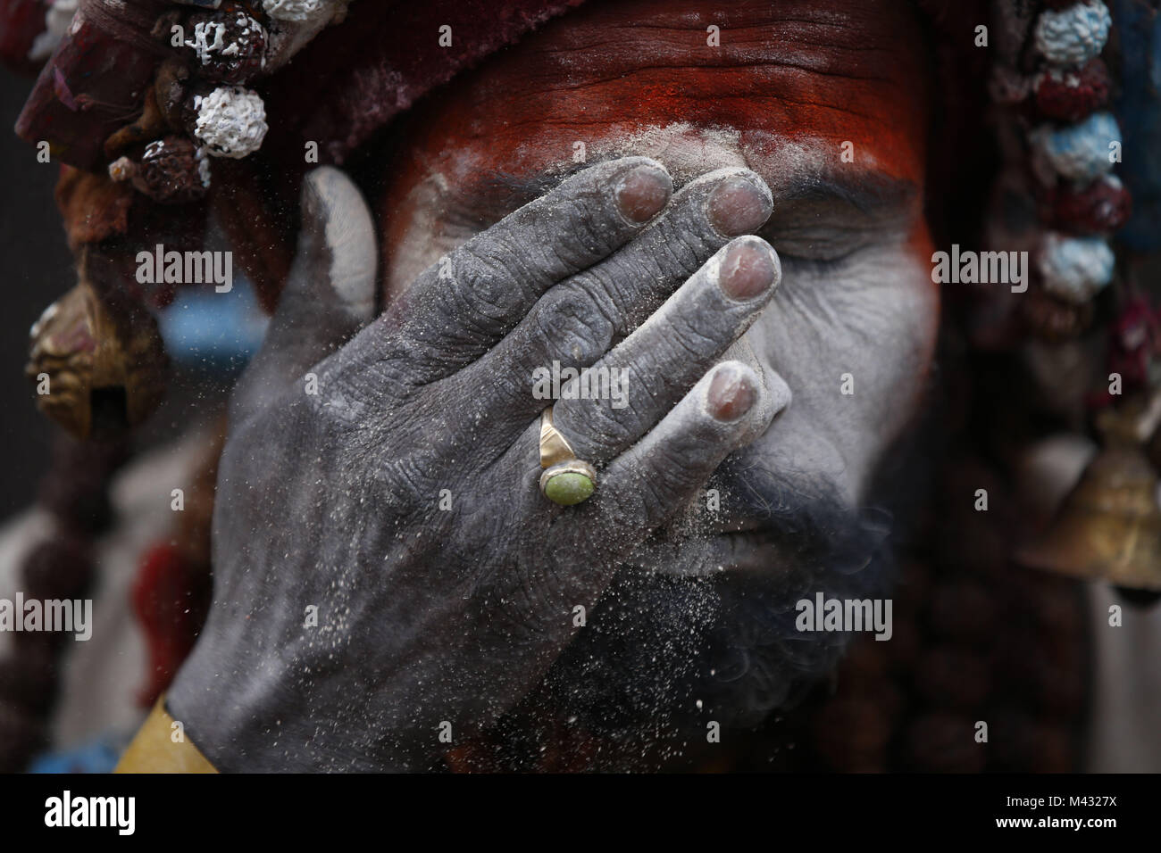 Kathmandu, Nepal. 13th Feb, 2018. A Sadhu or holy man smears ash on his face during Maha Shivaratri festival inside Pashupatinath Temple in Kathmandu. Thousands of sadhus from India and Nepal come to celebrate the festival of Maha Shivaratri by smoking marijuana, smearing their bodies with ash and offering prayers devoted to the Hindu Deity Lord Shiva. Credit: Skanda Gautam/ZUMA Wire/Alamy Live News Stock Photo