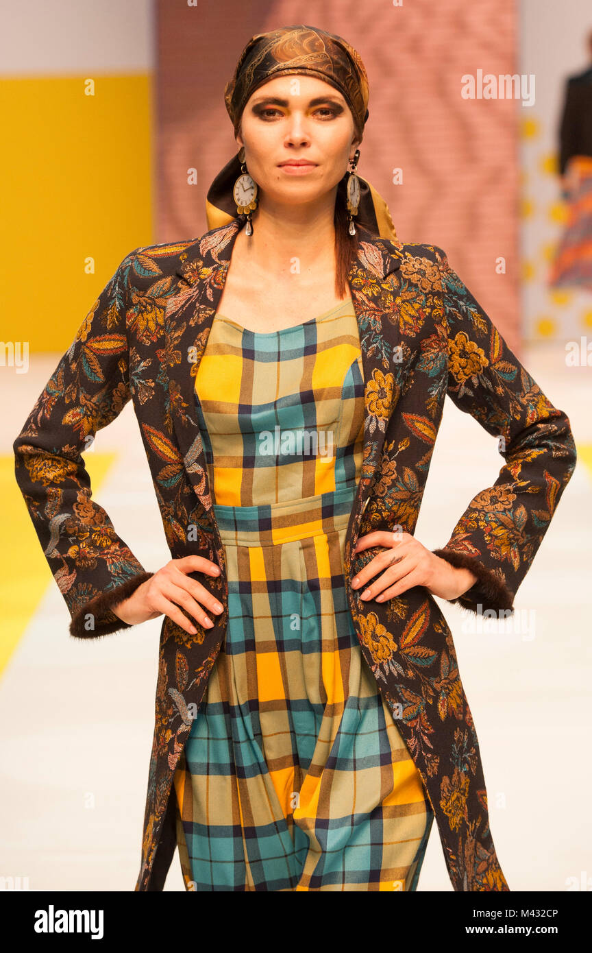 Fashion catwalk model at Pure London A/W 2018/19 at Olympia, London, UK. Model wears clothes by Villagallo and Bright & Beautiful. Hat by Fonem. Earrings by Kiwi + Pomelo. Pure London is the UK's largest trade fashion exhibition, running at Olympia 11th - 13th February, with two halls packed with brands and designers showcasing their latest clothing, shows, accessories, and jewellery, as well as the obligatory catwalk shows and guest industry speakers on stage each day. Fashion buyers from across the UK have flocked to the exhibition. 13th February 2018. Stock Photo