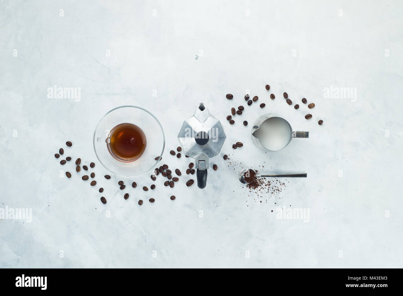 Header with coffee maker minimalist flat lay with coffee beans, milk, ground coffee and geyser coffee maker. Alternative brewing. High key drink photo Stock Photo