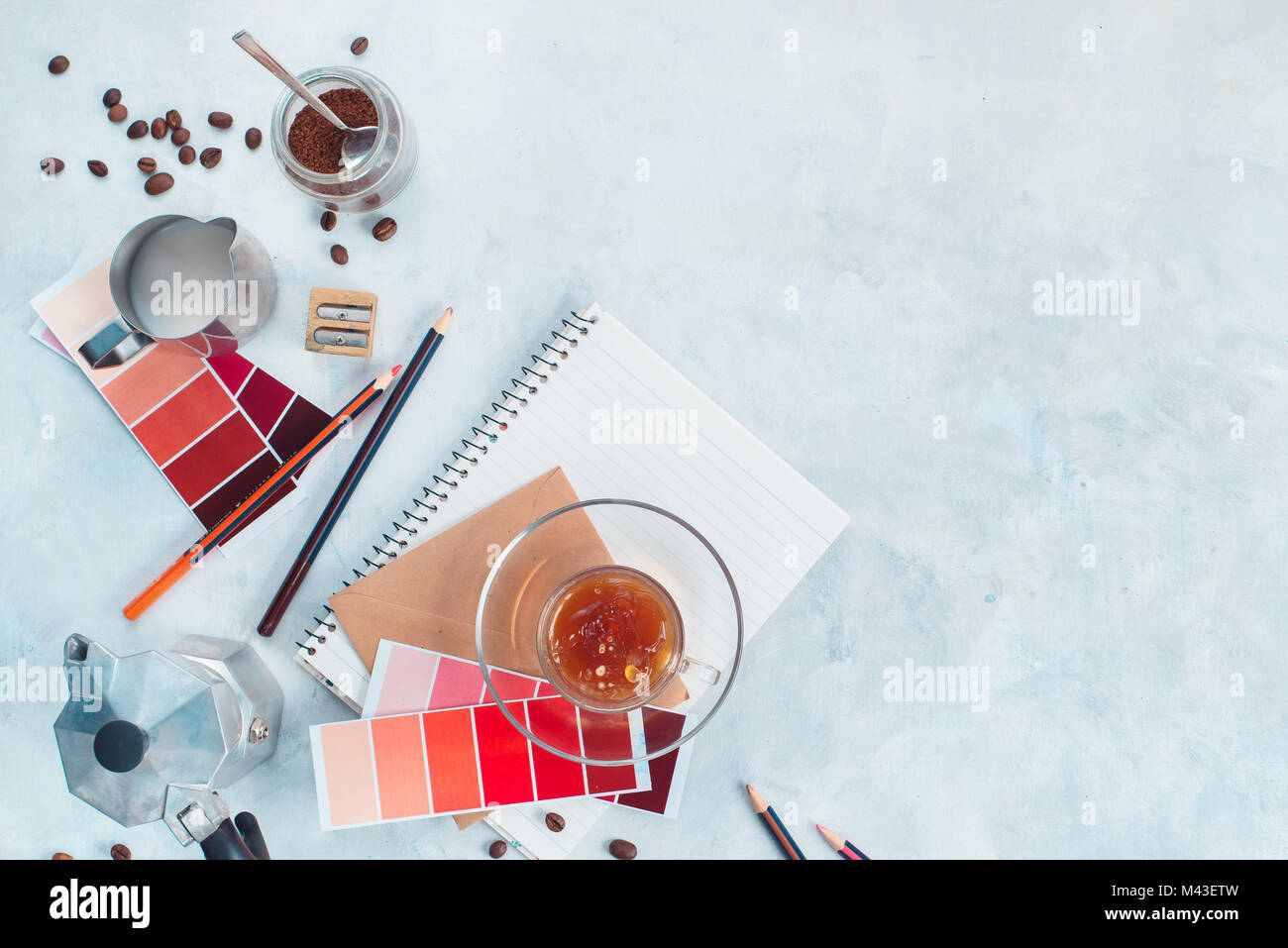 Designer workplace with coffee pot, color swatches, notes and coffee cups. Creative top view hot drink concept with copy space. Stock Photo