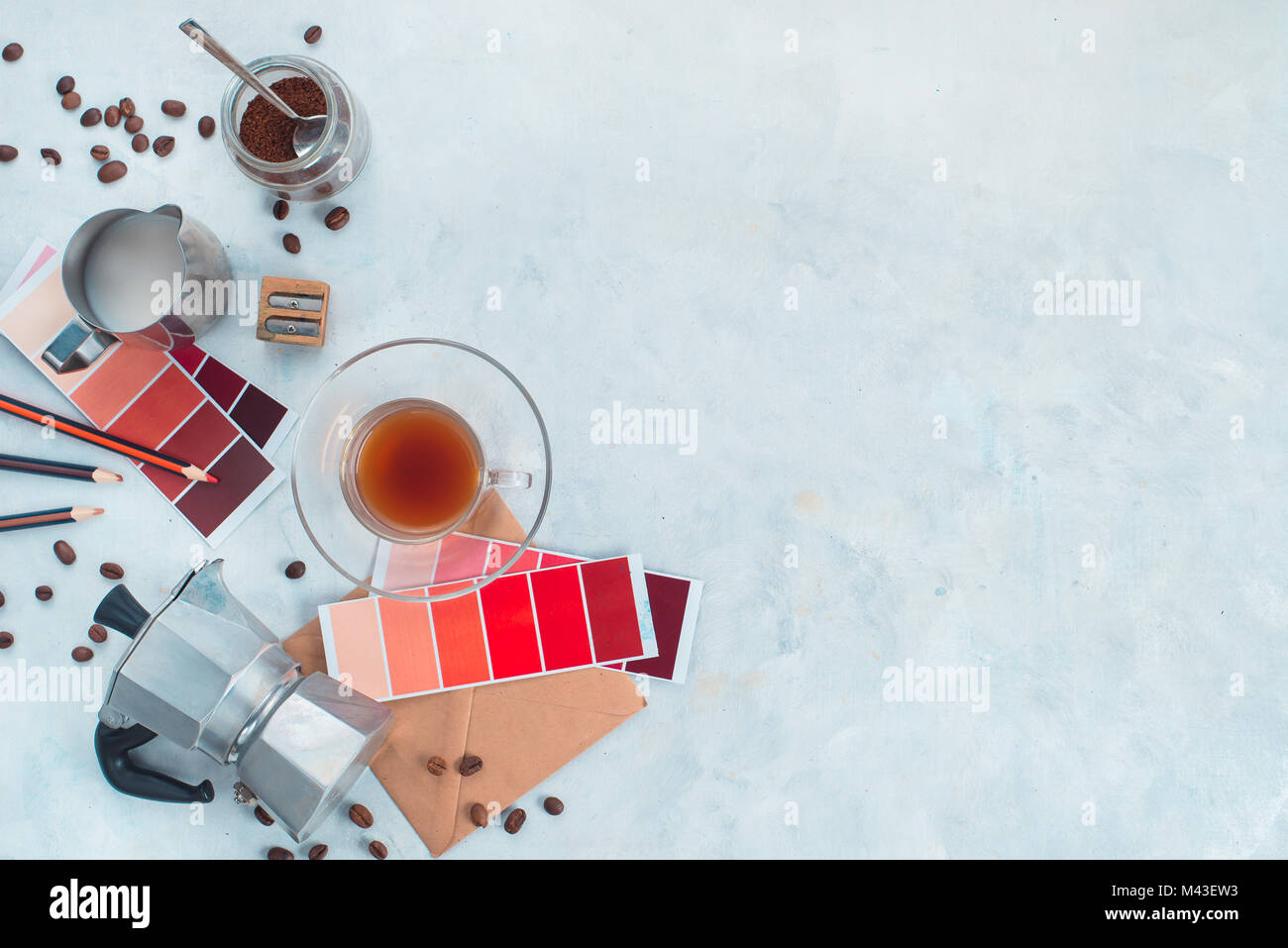 Color design production. Artist workplace from above. Moka coffee pot, color swatches, pencils, notes and coffee cups. Creative occupation concept. Stock Photo