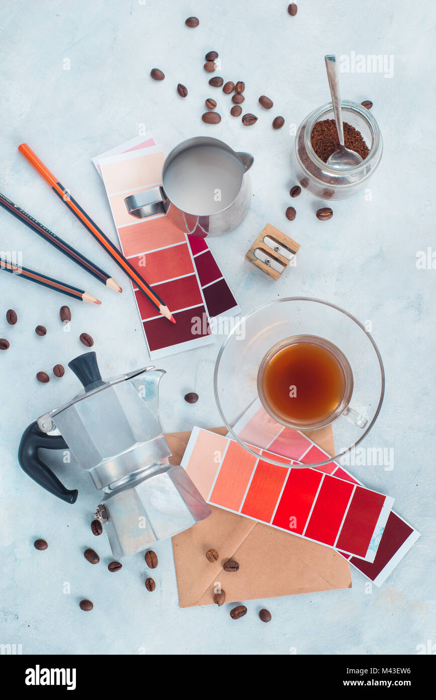 Nordic style flat lay with a designer workplace. Moka coffee pot, color swatches, pencils, notes and coffee cups. Creative occupation concept. Stock Photo