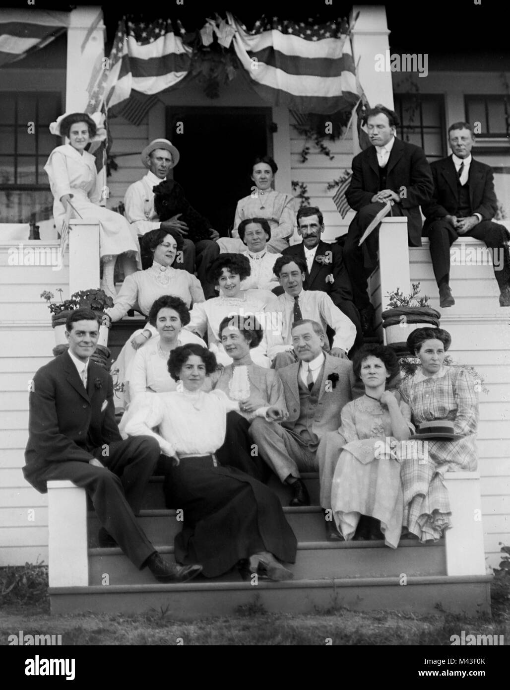 Extended family portrait on the front porch of large home, ca. 1910. Stock Photo