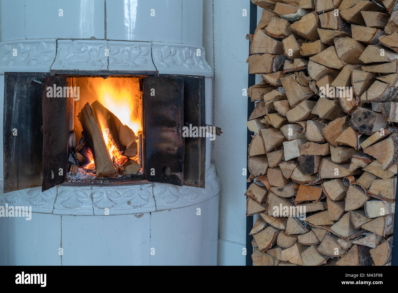 fire in a tiled stove with white tiles Stock Photo Alamy