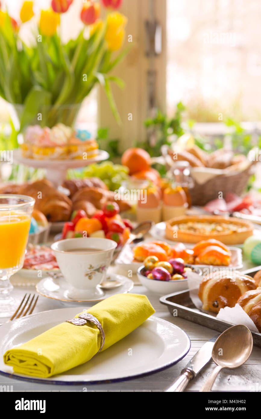 Breakfast or brunch table filled with all sorts of delicious delicatessen ready for an Easter meal. Stock Photo