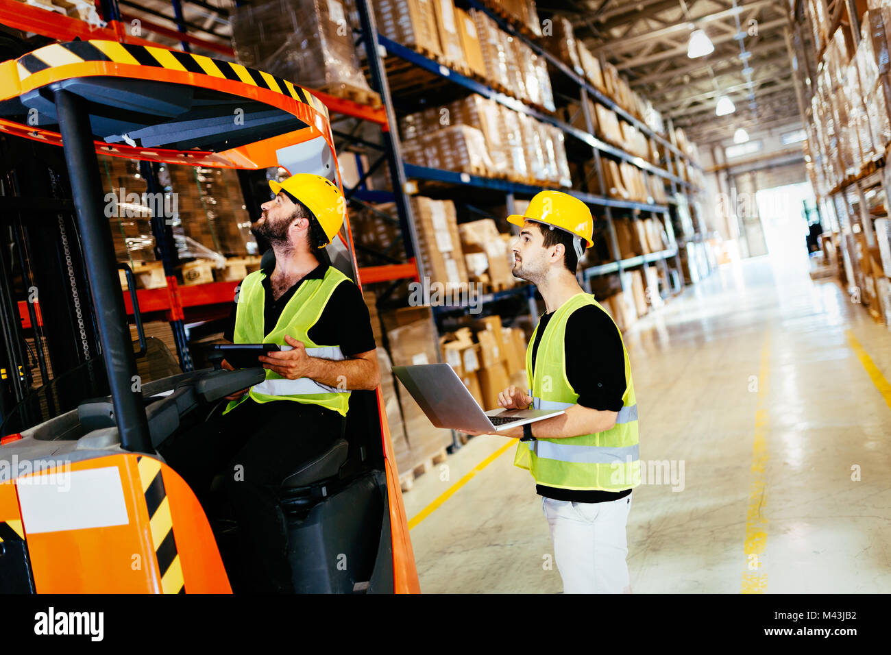 Warehouse workers working together with forklift loader Stock Photo