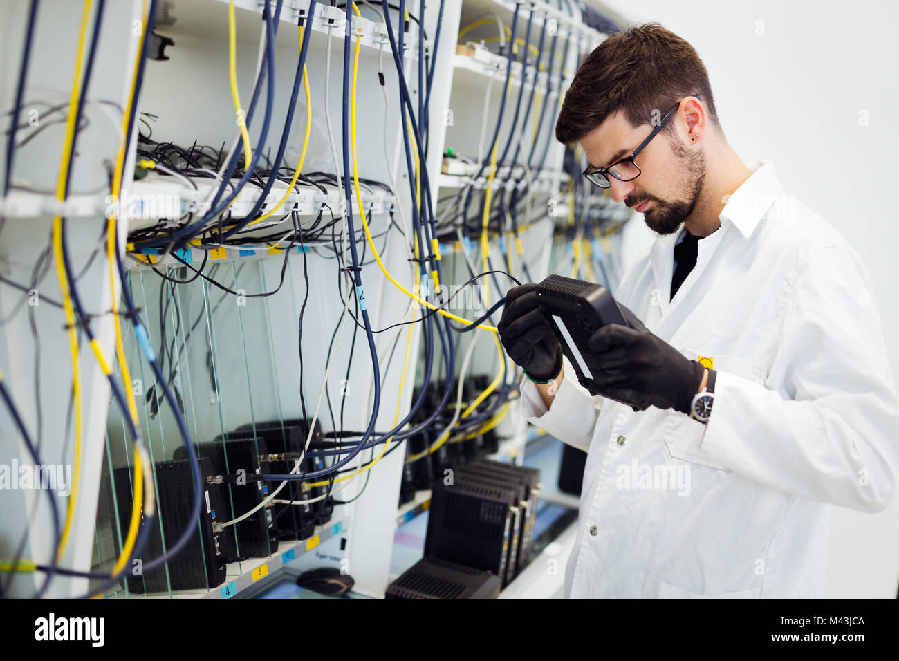 Picture of network technician testing modems in factory Stock Photo Alamy