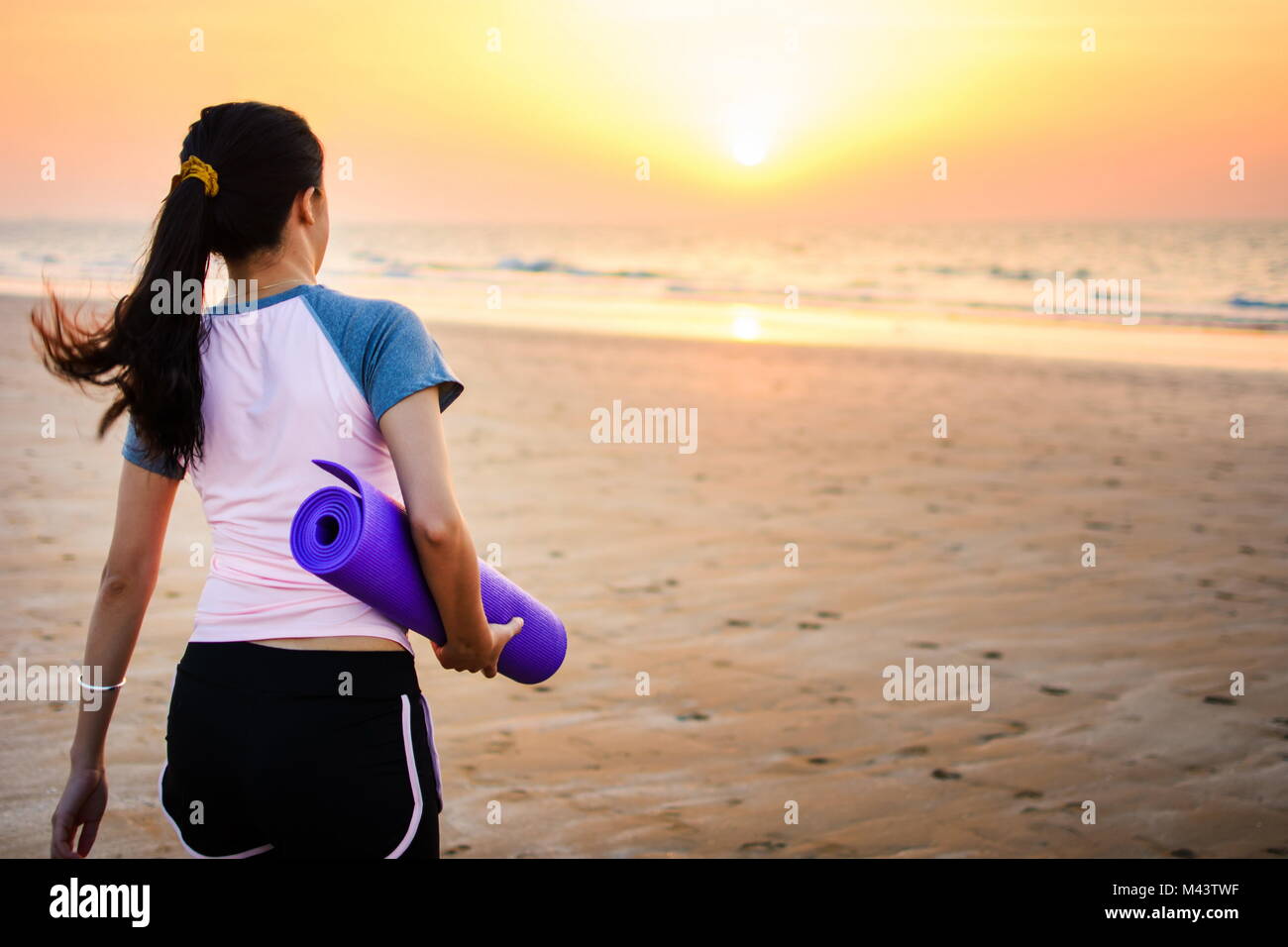 Girl with yoga mat on the beach for outdoors workout Stock Photo Alamy