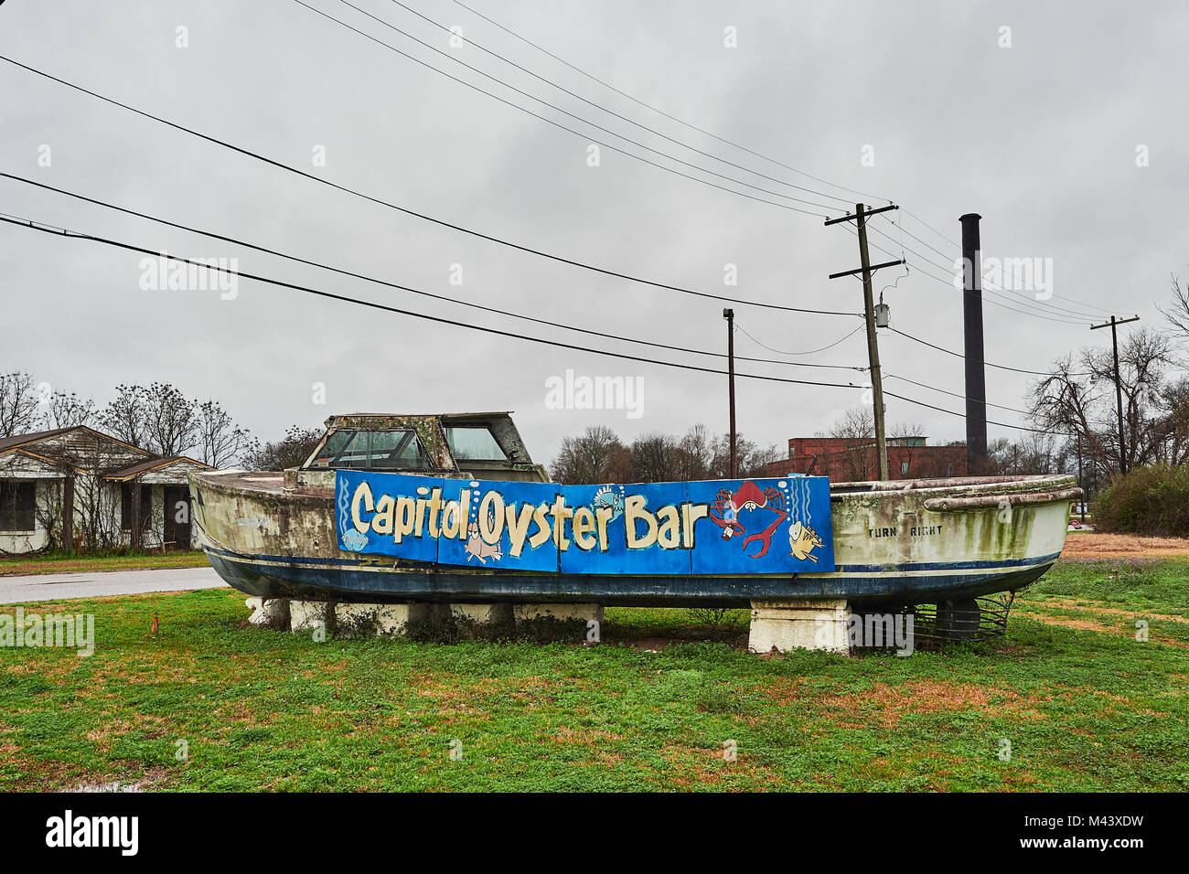 Brightly painted advertising sign on a dirty dilapidated old fishing boat promoting the Capitol Oyster Bar in Montgomery, Alabama USA. Stock Photo