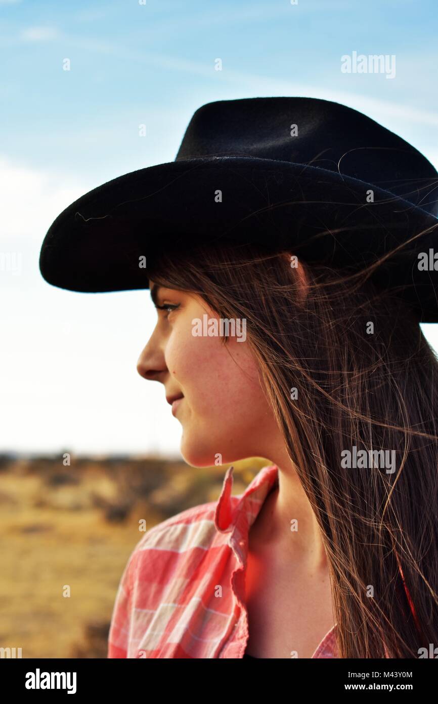 Girl In Black Cowgirl Hat Looking Off Into The Desert Stock Photo