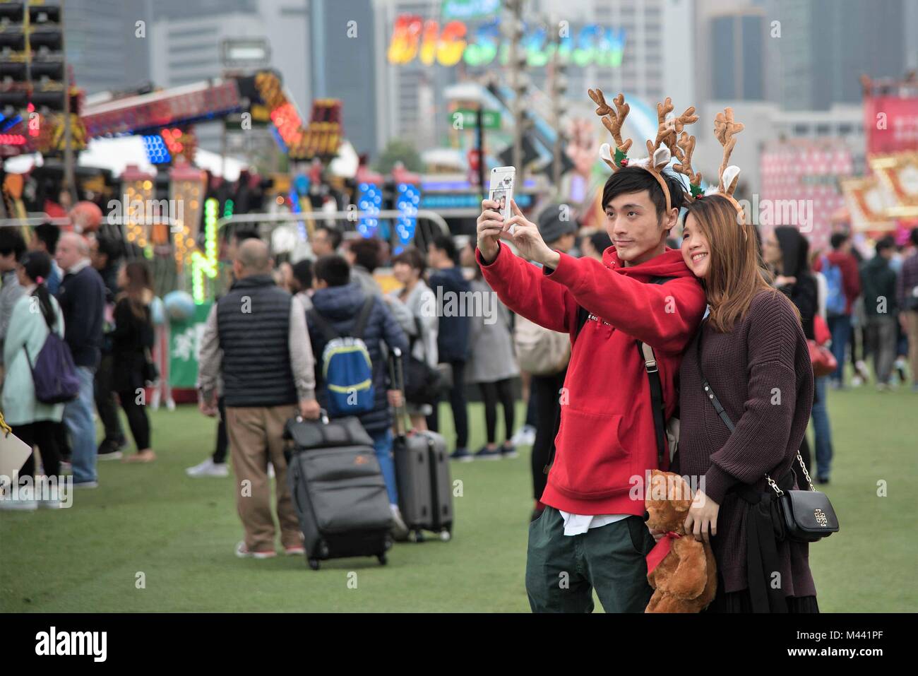 A couple takes a selfie at the AIA European Carnival on Christmas eve 2016, while the smartphone also contains a pic of the couple. Stock Photo