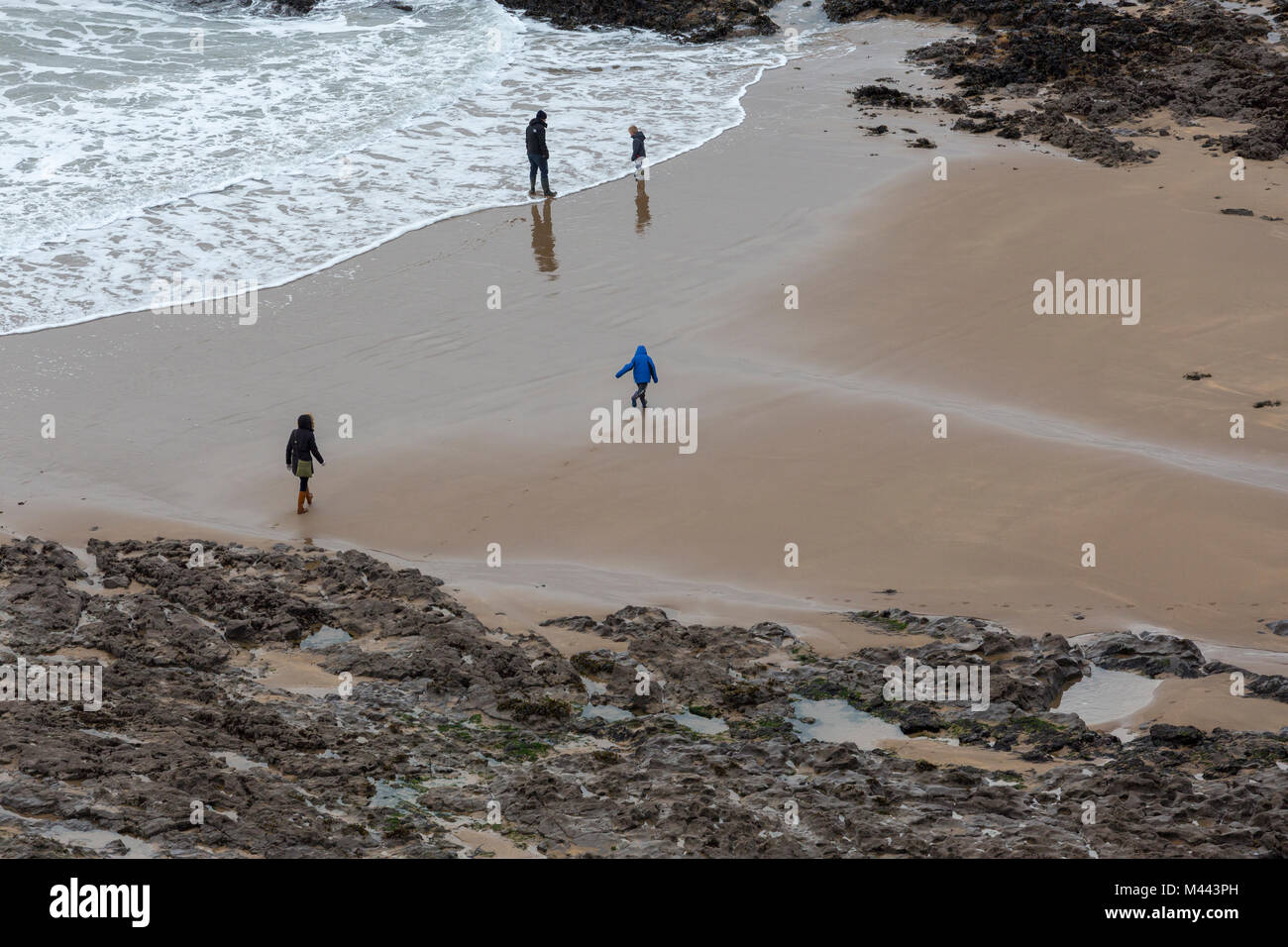 Family with children on holiday playing on beach in winter off-season Stock Photo