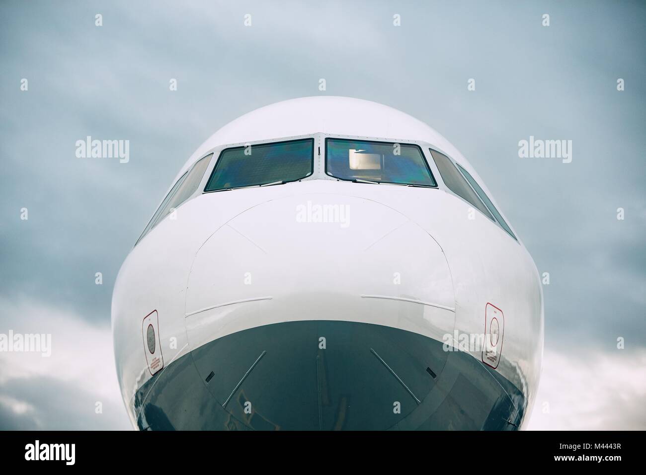 Front view of the airplane nose against cloud sky. Stock Photo