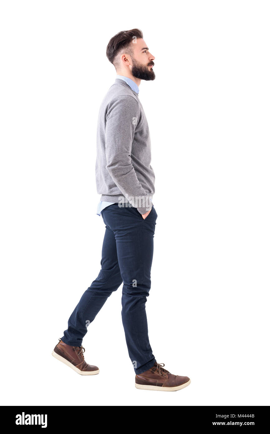 Confident successful smart casual businessman walking with hands in pockets. Full body length portrait isolated on white studio background. Stock Photo