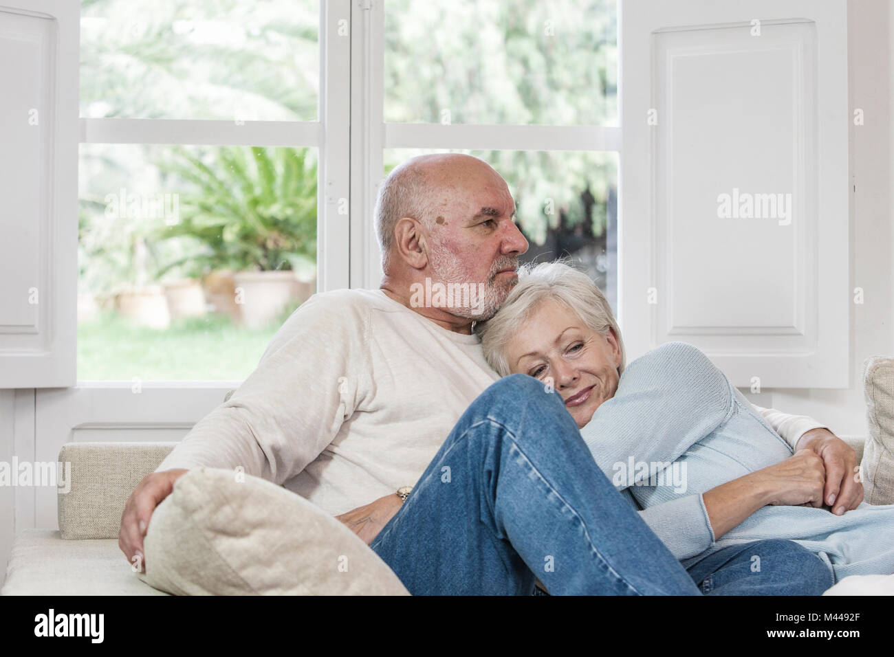 Senior couple relaxing together on sofa Stock Photo - Alamy