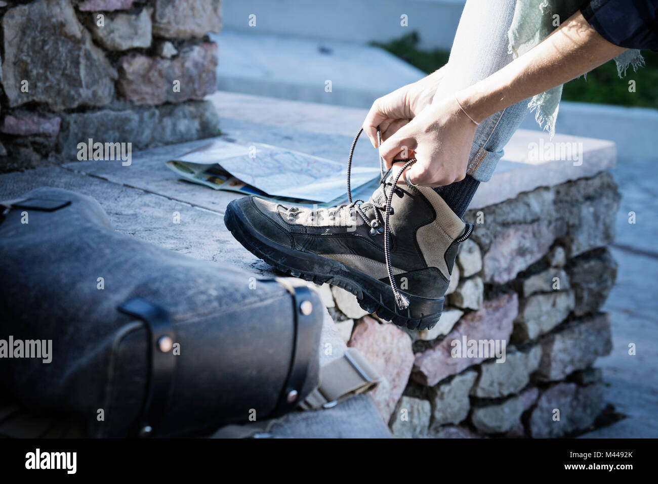 Cropped view of woman tying shoelace on walking boot Stock Photo