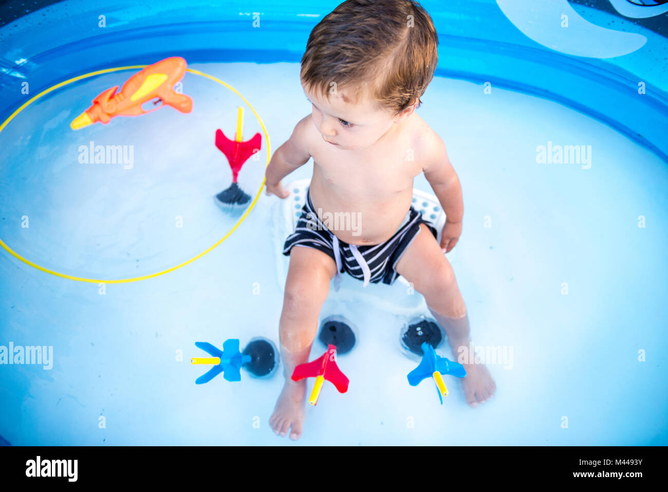 Baby boy sitting in paddling pool Stock Photo Alamy
