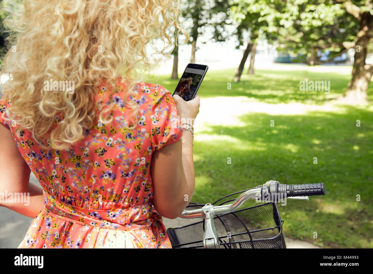 Woman with bicycle using smartphone Stock Photo