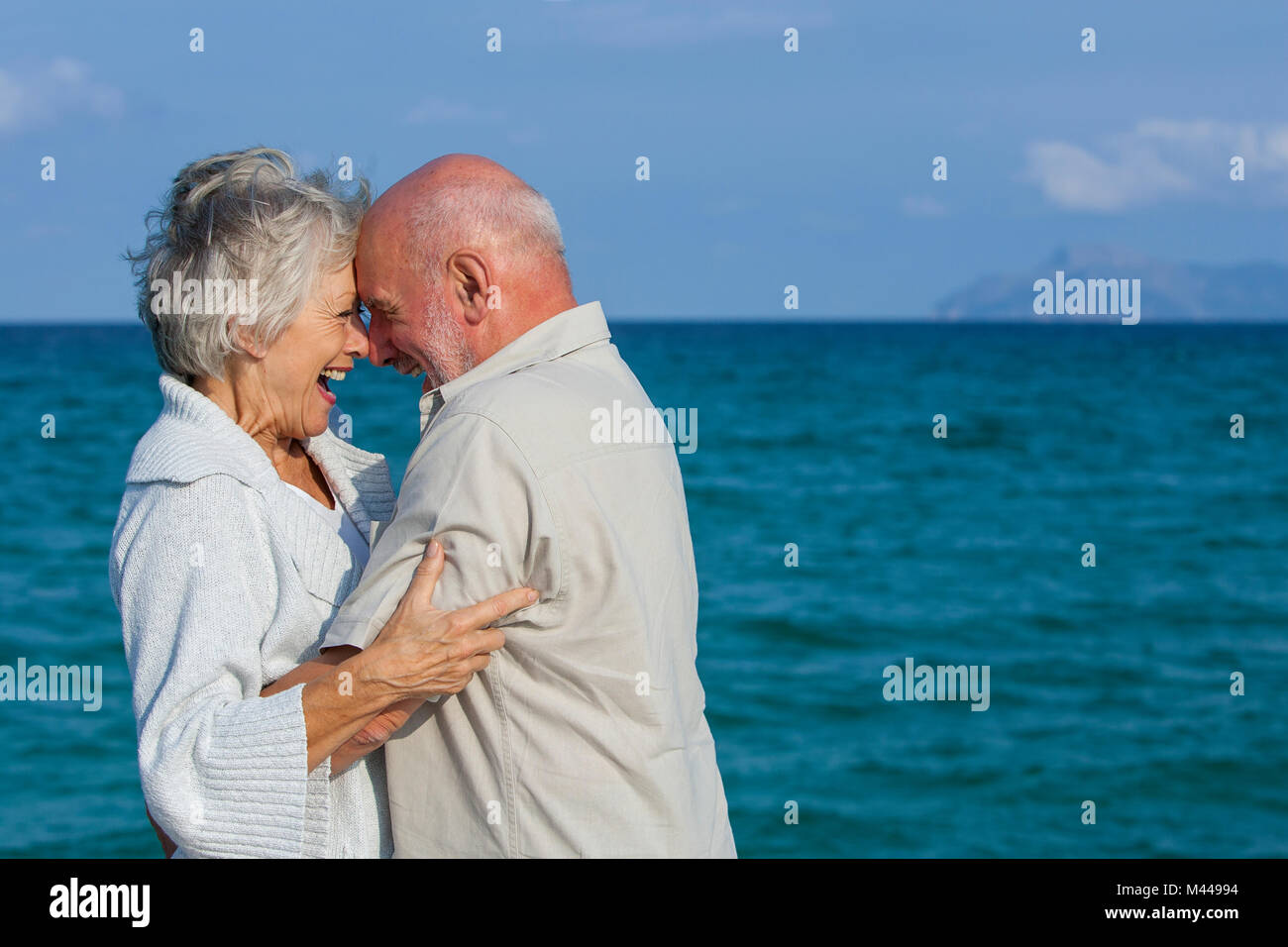 Couple hugging and laughing by seaside Stock Photo