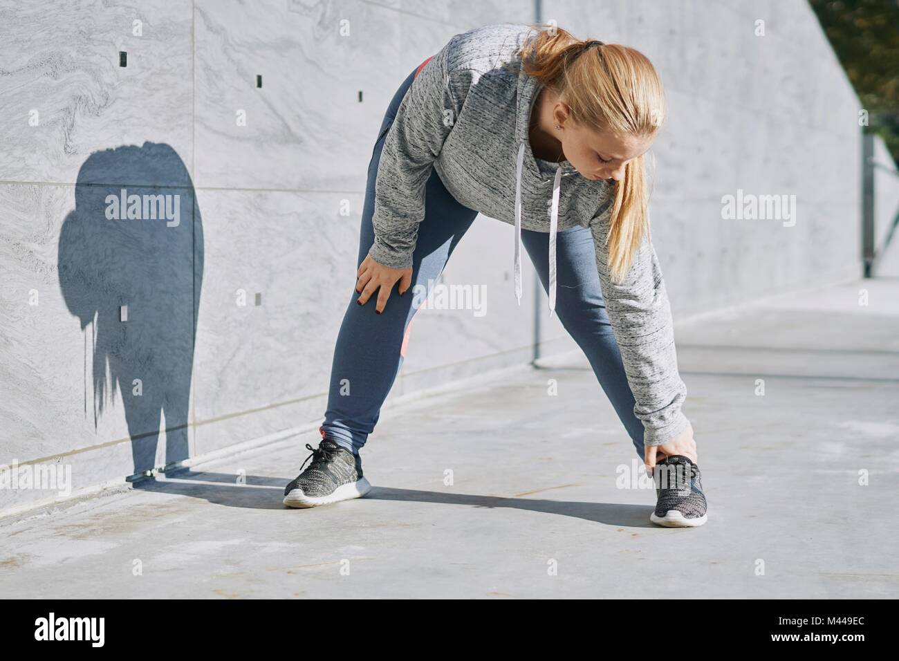 Curvaceous young woman training, touching toes Stock Photo