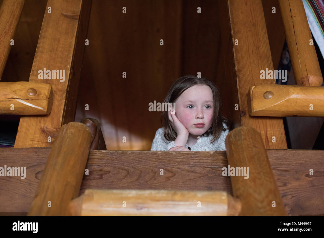 Girl lying on loft floor feeling bored Stock Photo