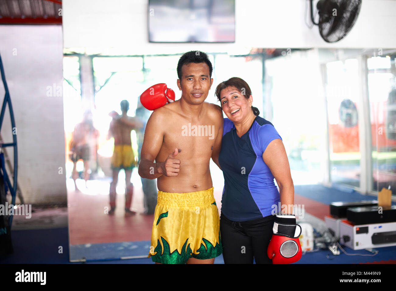 Portrait of mature woman with boxing trainer in gym Stock Photo